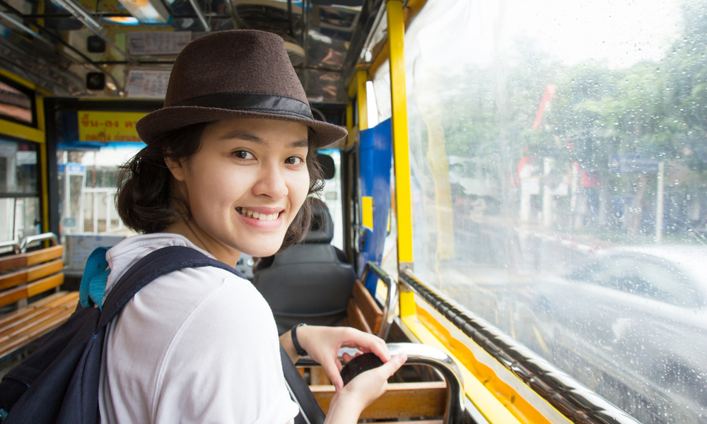 how to travel cheap: Young Asian woman in the bus with rainy day.