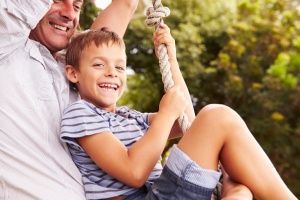 Best Free Things You Can Do in Denver with Kids: Father swinging with son at a playground