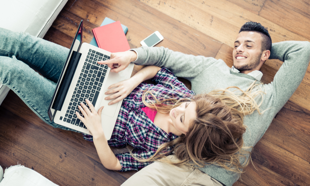 How to travel cheap: couple checking their travel budget on a laptop