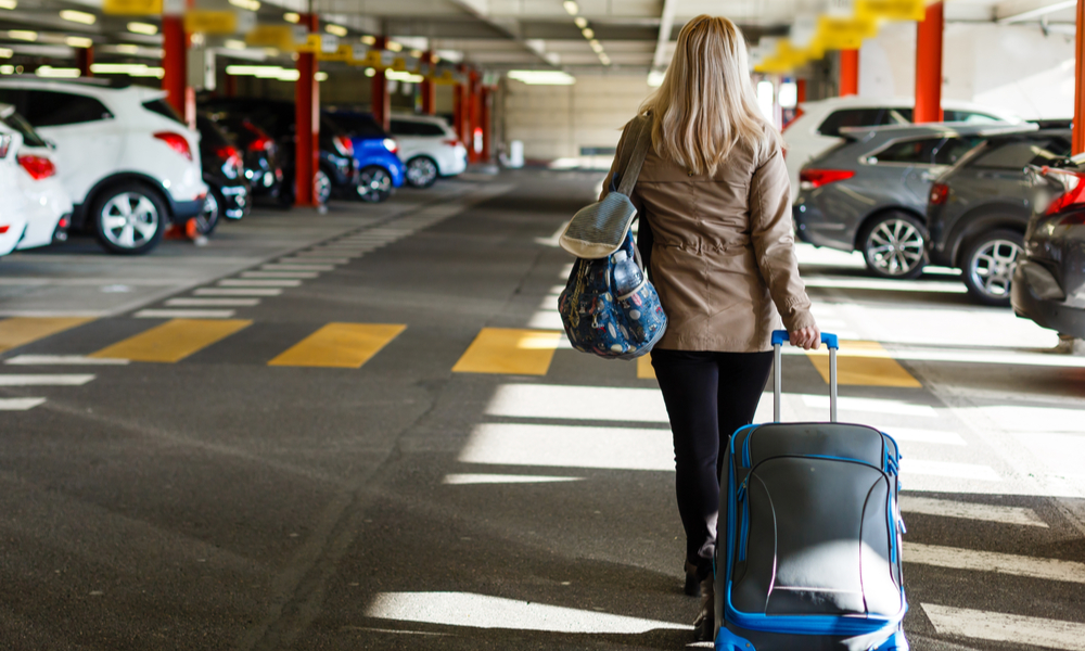 tips for and alternatives to parking at the airport: girl with bags at airport parking