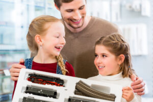 family playing with train playset