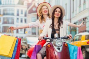 two girls shopping riding motorbike