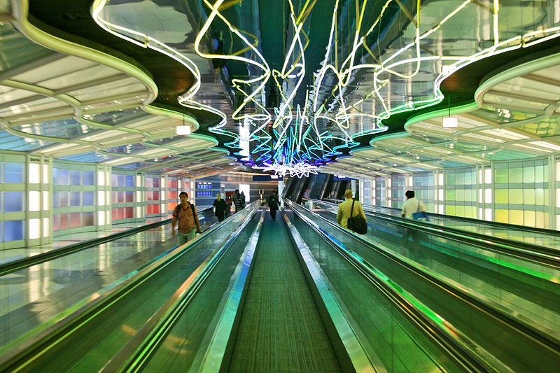 Passengers travel through O'Hare Airport's neon walkway (Image: 
Wikimedia)