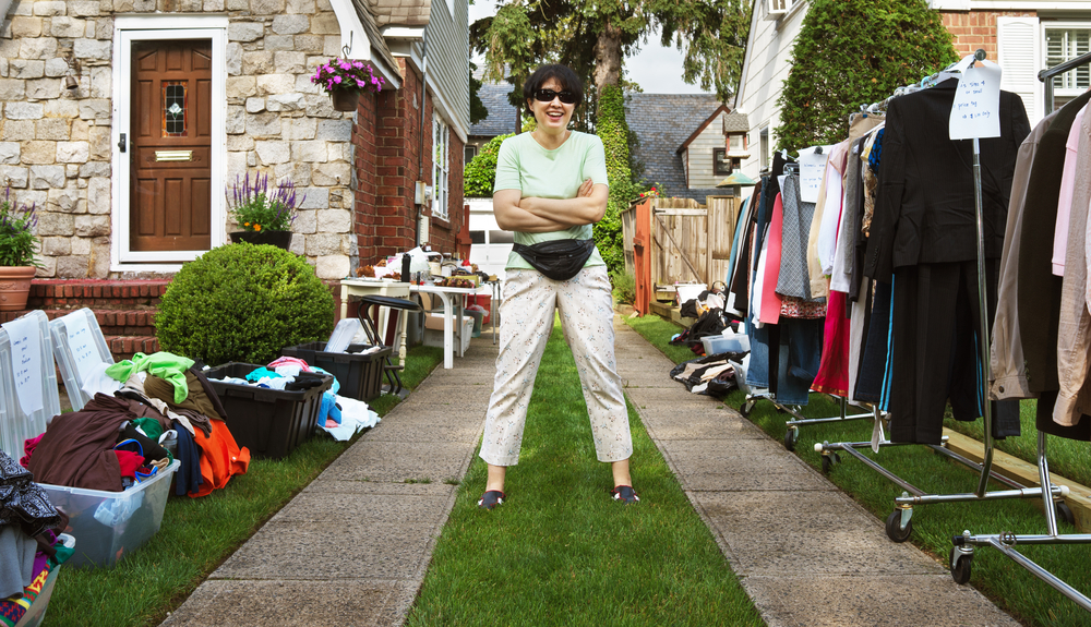 happy woman ready to sell items at yard sale.