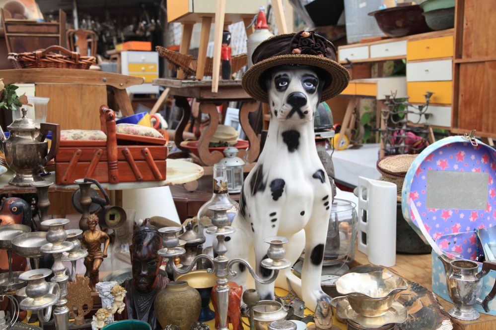 Old vintage objects and furniture for sale at a flea market. Toy vintage dog.