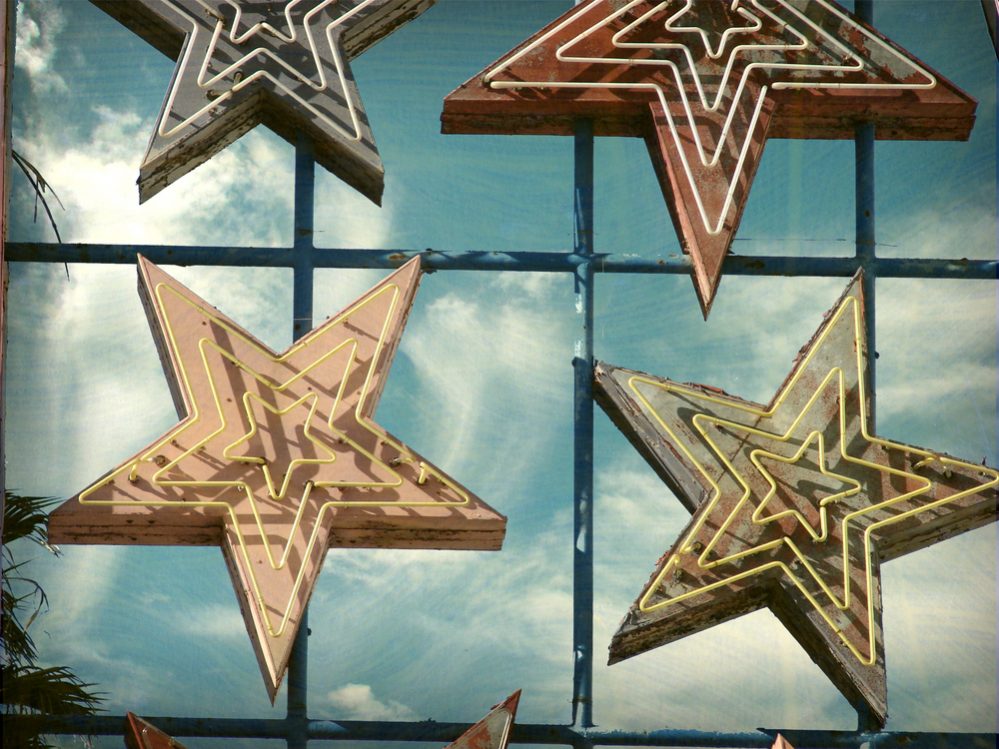 aged and worn vintage photo of neon sign stars