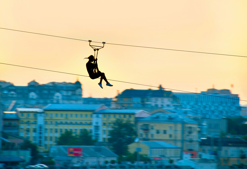 woman ziplining over city