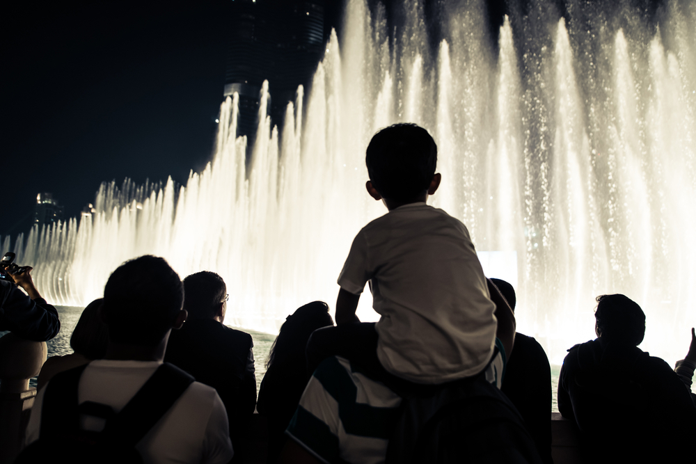 group of tourists watching fountain show