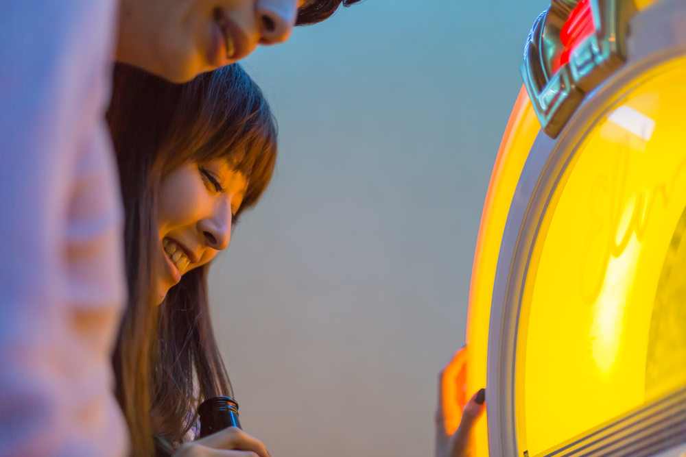 Japanese young couple setting on a jukebox