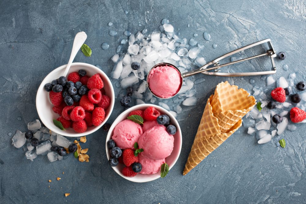 Raspberry ice cream in white bowl overhead shot