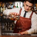 Bartender pouring fresh cocktail in fancy glass