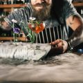 Happy barman is making cocktail with ice vapor at night club. Unique man. Bartender has a mustache and stylish hairstyle