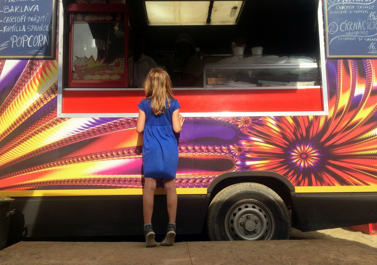 girls standing in front of food truck