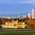 Denver Colorado skyline from City Park with City Park Boathouse and Rocky Mountains in background on autumn morning