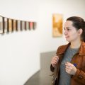 Portrait of happy adult brunette woman in art museum