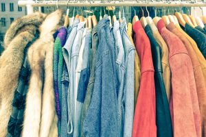 Vintage second hand clothes hanging on shop rack at weekly flea market