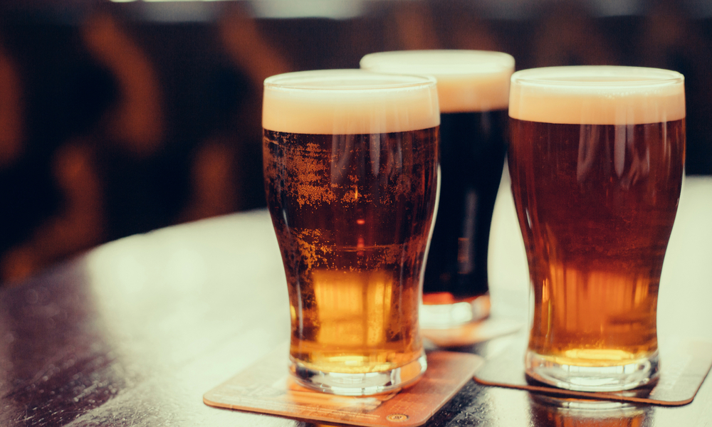 Glasses of light and dark beer on a pub background.