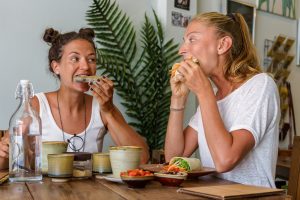 Young women eating vegetarian food and drink coffee in a cafe