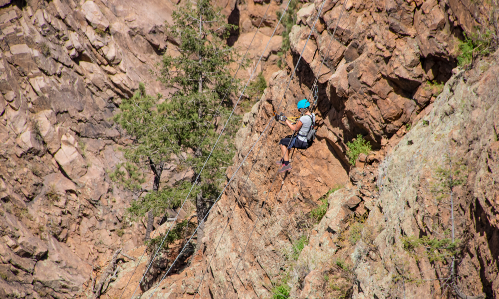  Exciting & adventurous things to do in denver: Woman ziplining down a cliff in the Rocky Mountains of Colorado