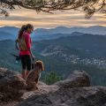 Exciting & adventurous things to do in denver: A hispanic woman is hiking with a dog, in the Rocky Mountains, of Colorado.